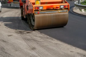 מכבש רולר מסוג דחיסה משטח אספלט טרי במהלך סלילת כביש